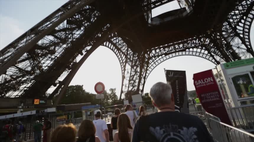 A group of people walk towards the eiffel tower