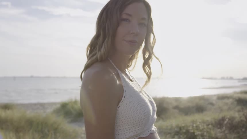 A woman smiles looking away from the water