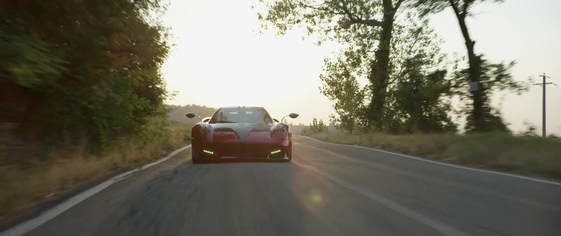 A sports car speeds along a country road