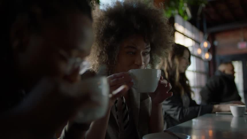 A couple talk and drink coffee in a cafe