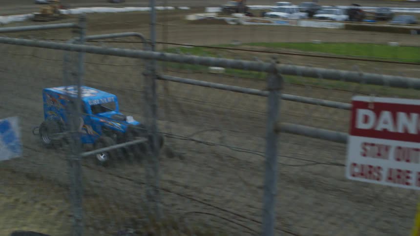 Vehicles race around the dirt track