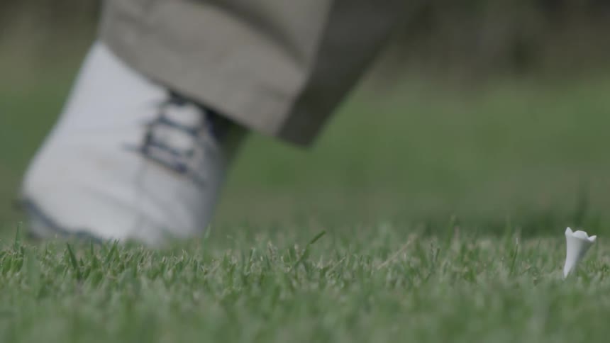Close up of a person hitting a golf ball with a club