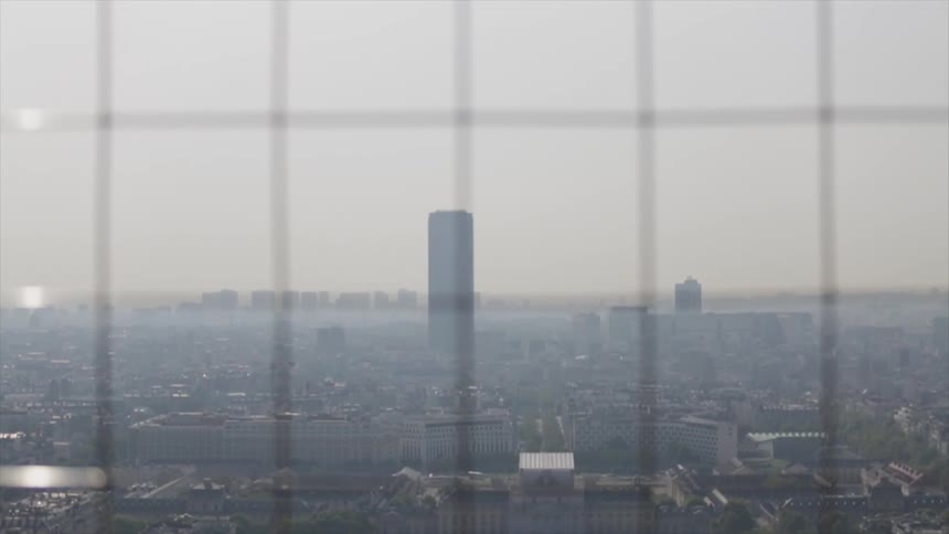 Haze hangs over a city skyline during the day