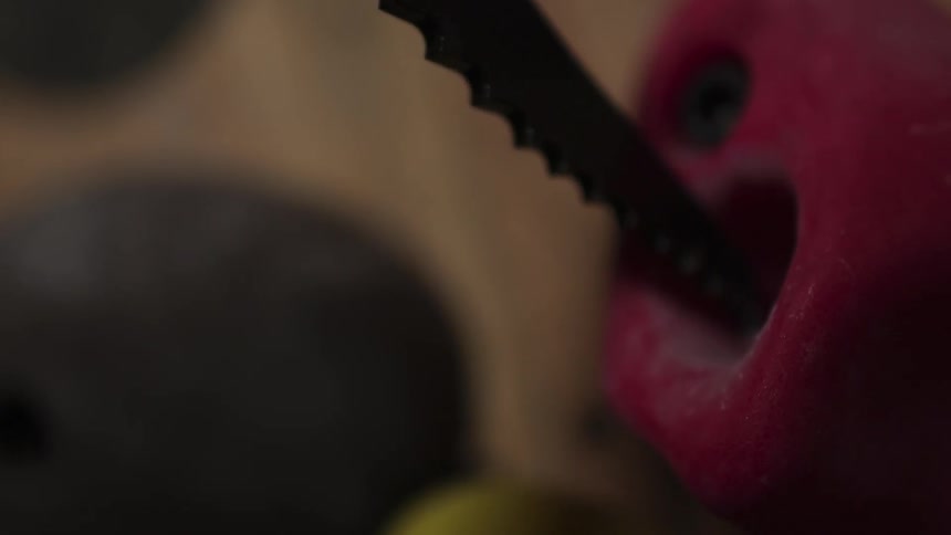A person carves a small red figure