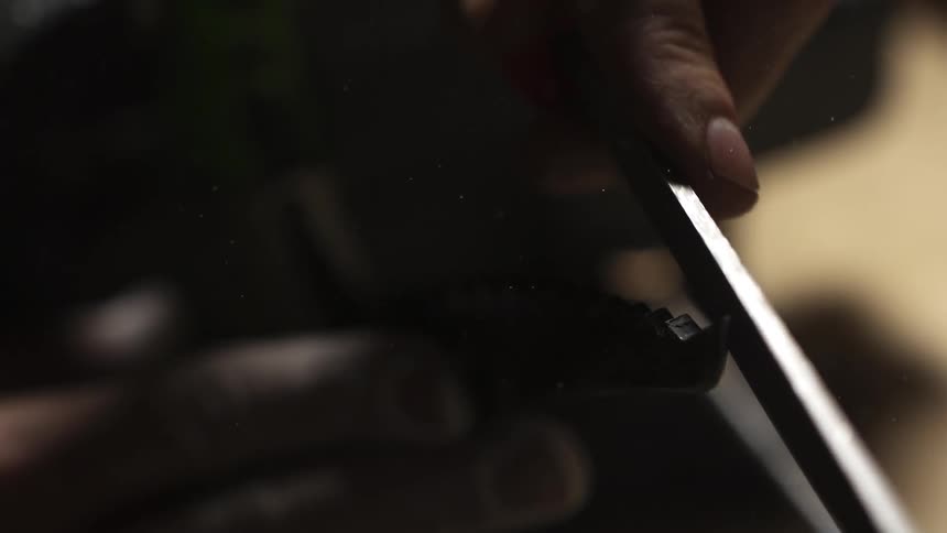 A person uses a file to sharpen a tool