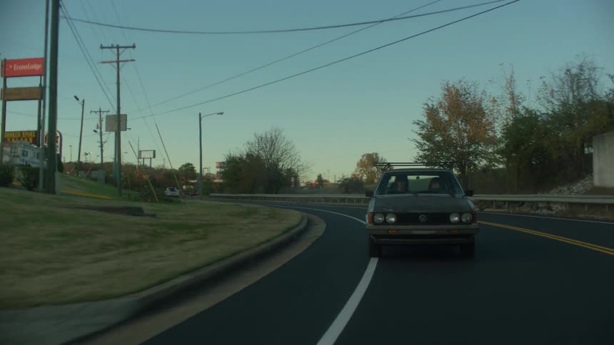A car turns off onto the road on a sunny day