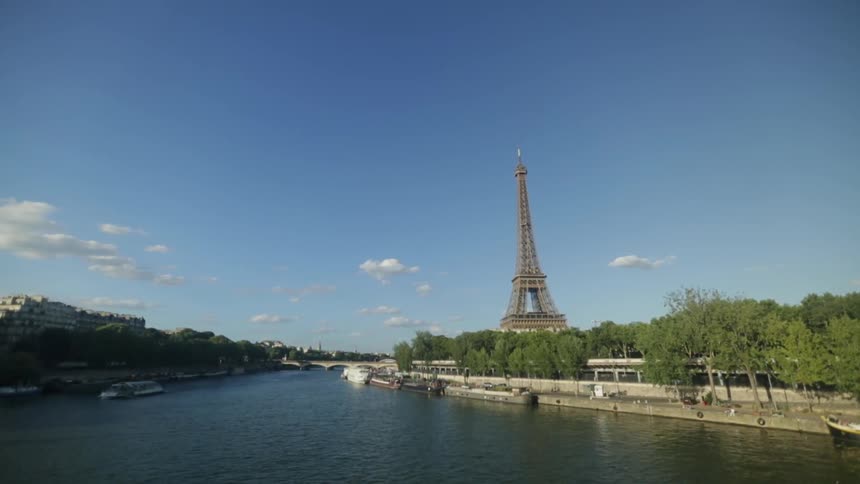 The eiffel tower towers into the sky next to a canal