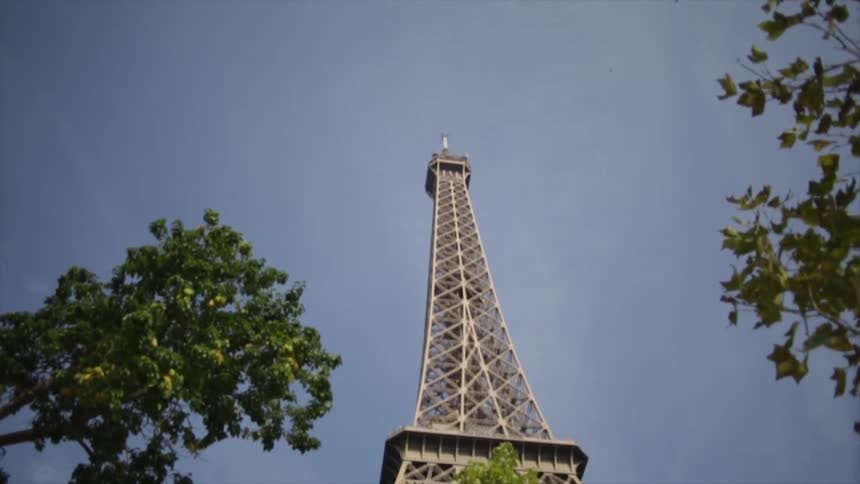 The eiffel tower stands overhead on a sunny day