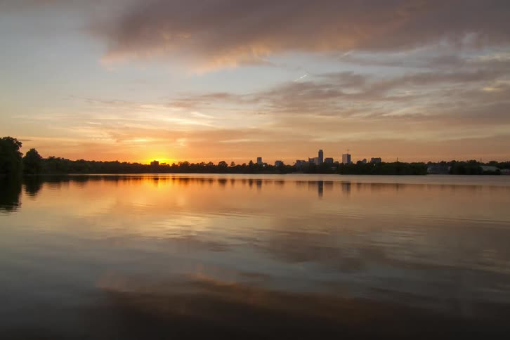 Clouds move across a city and bay at sunset