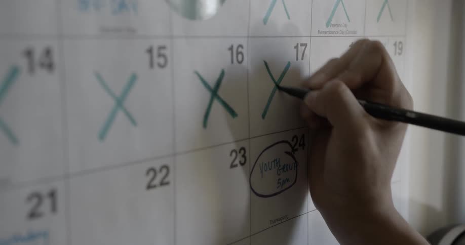 A person crosses off a date on a calendar