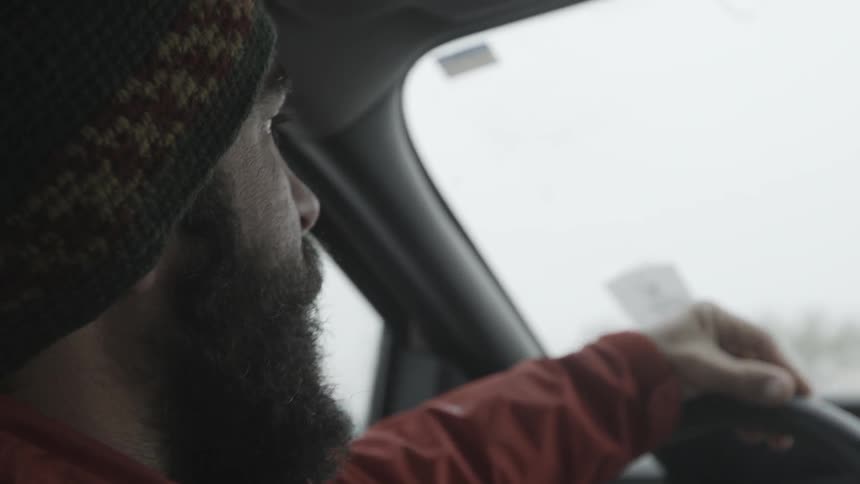 Bearded man talking as he drives a vehicle