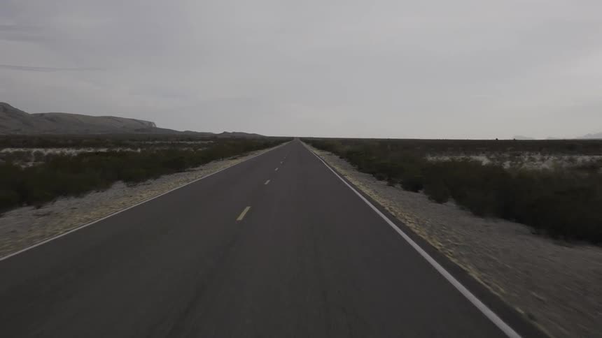 The road ahead is empty with heavy clouds in the sky