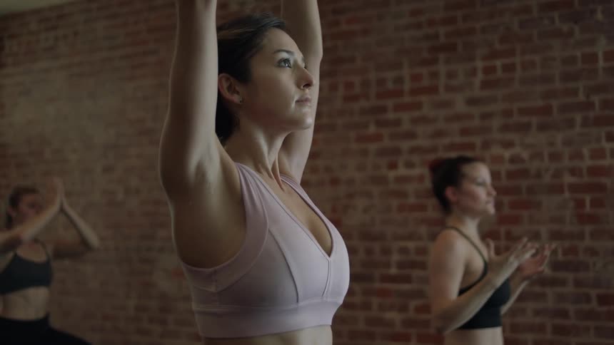 Women do yoga in a brick building