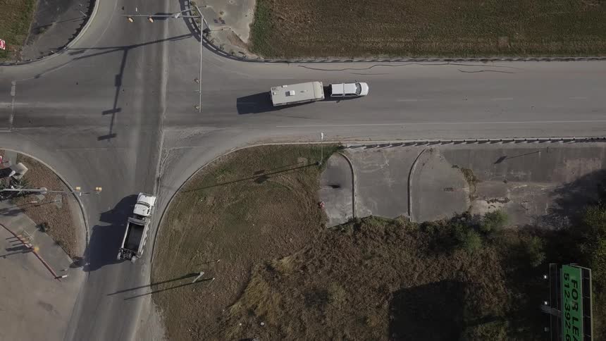 Cars and trucks travel through a four way intersection