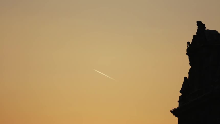 Airplane makes a small scratch in the sky at sunset
