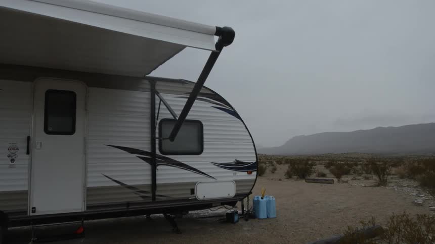 A trailer with an awning sits parked