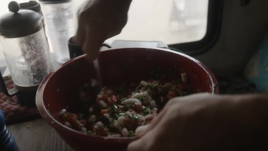 Person stirs vegetables in a small bowl