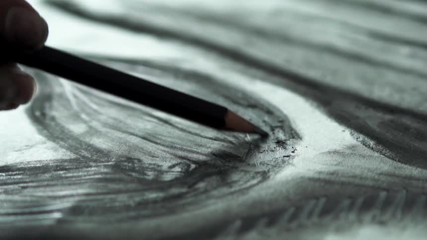 An artist sketches with a pencil
