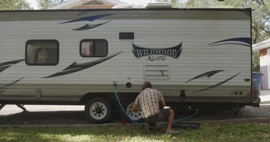 A man changes the tire on an rv