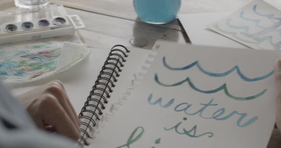 A person tears a piece of paper out of a notebook