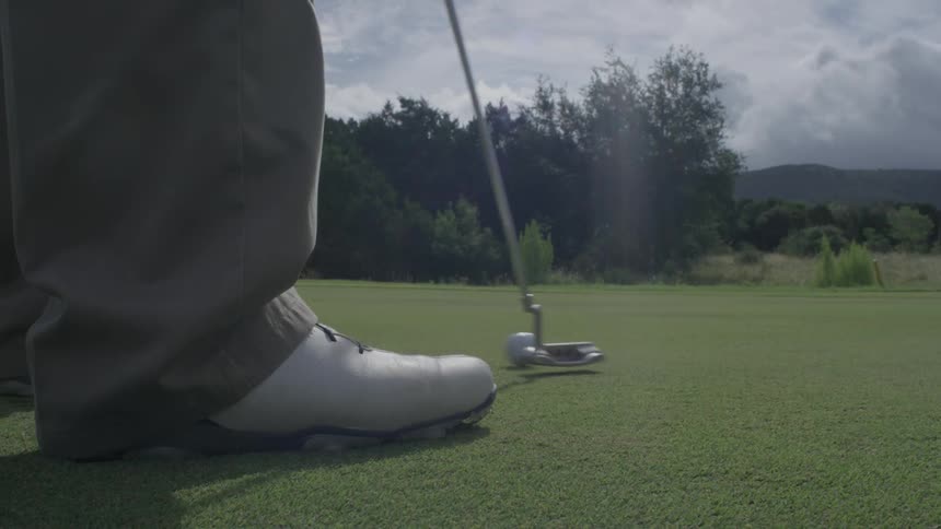 A man putts the golf ball