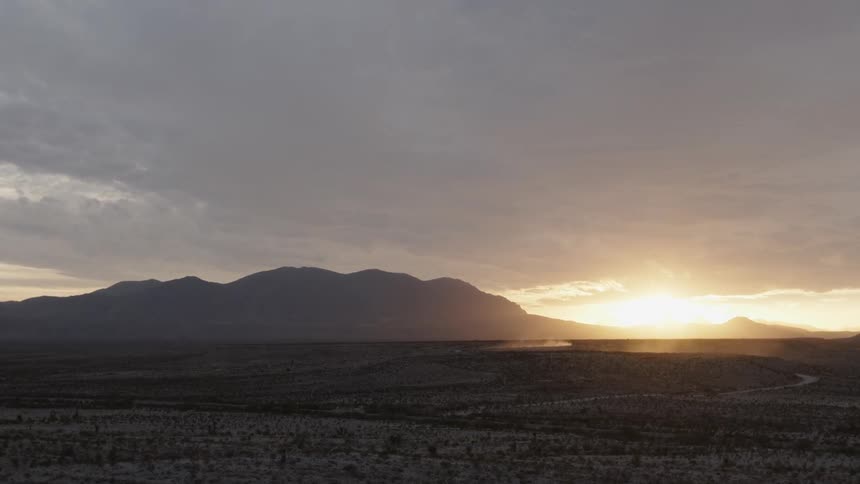 The sun sets over a mountain