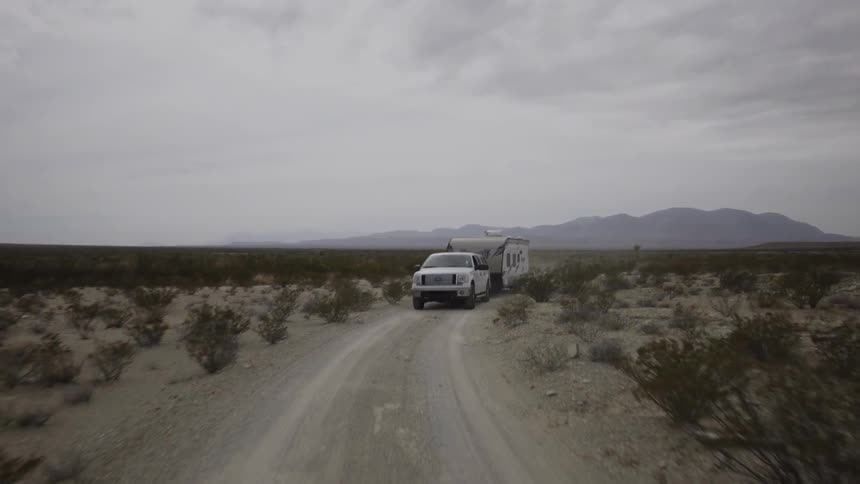 A person hauls a trailer while driving a truck