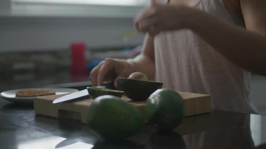 A woman cuts avocado