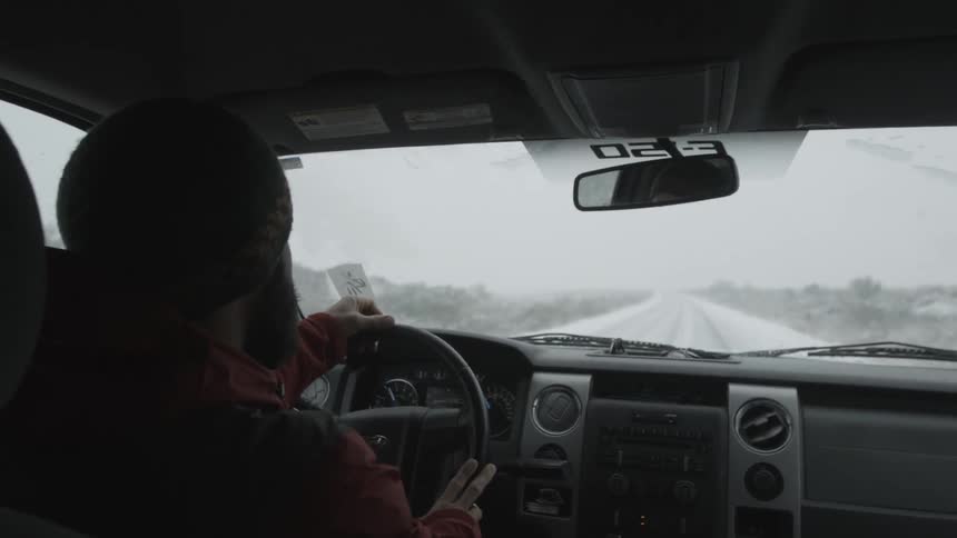 A man drives a truck through the snow