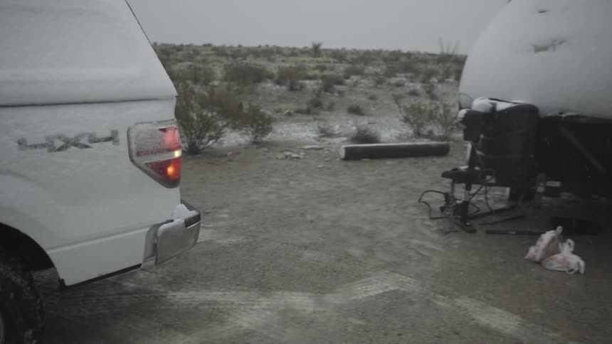 A truck backs up to hitch a caravan