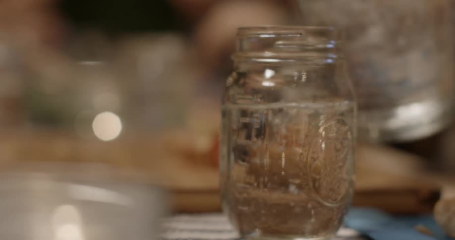Someone pours water into a jar