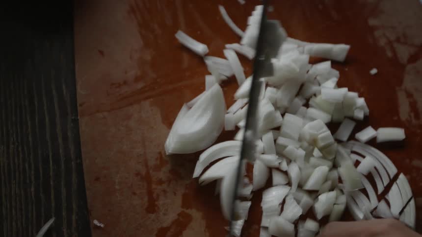 Someone chopping onions with a knife
