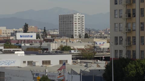 Traffic moves on a freeway in an urban area during the day