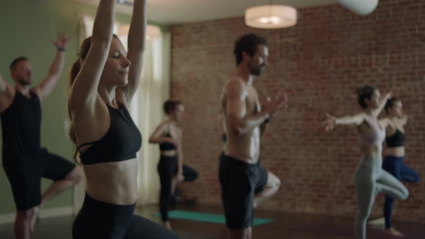 A group of men and women stretch and do yoga