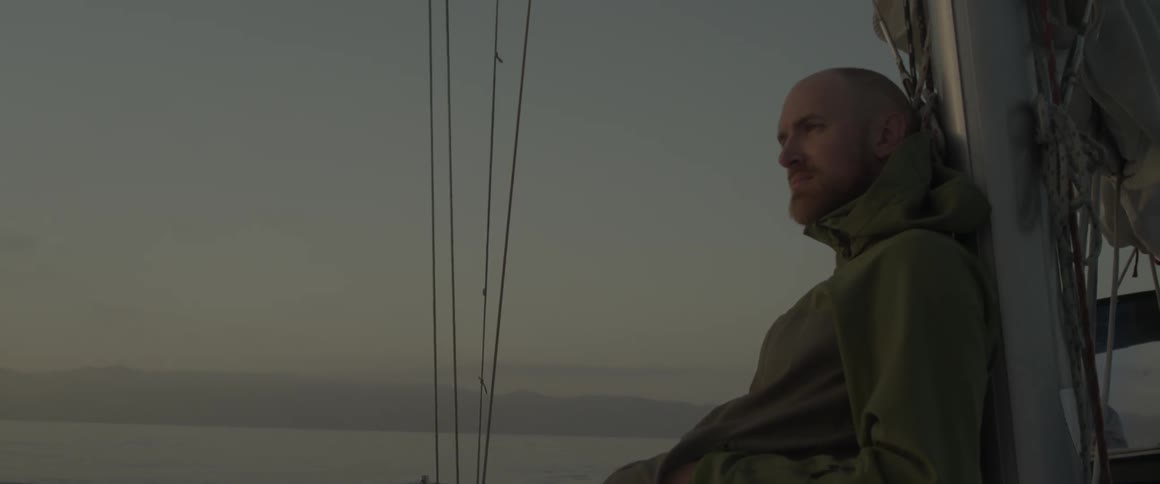A man wearing a jacket sits on a boat