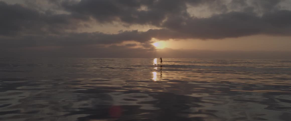 A man paddles on a board in the ocean