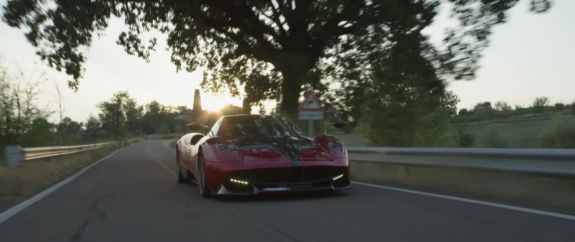 A sports car speeds down a country road