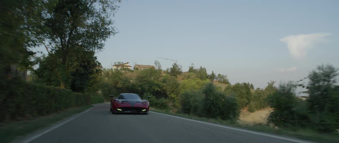 A sports car drives on a rural mountain road