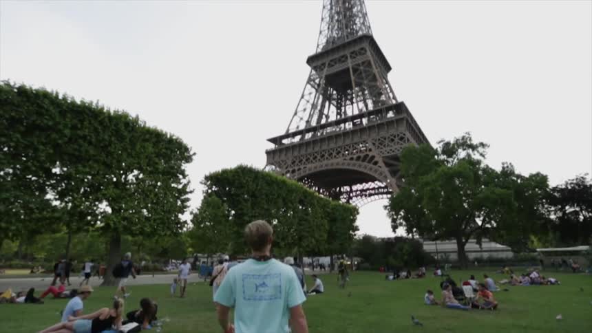 A group of people walk and sit near the eiffel tower