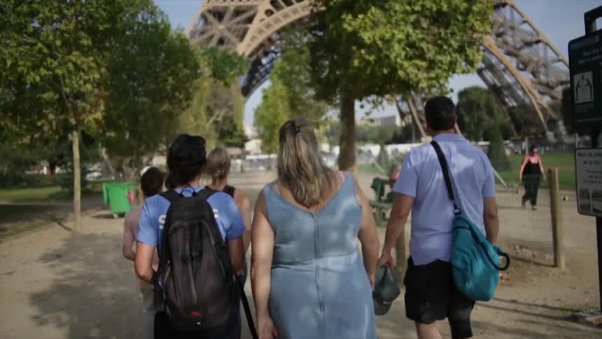 A group of people walk towards the eiffel tower