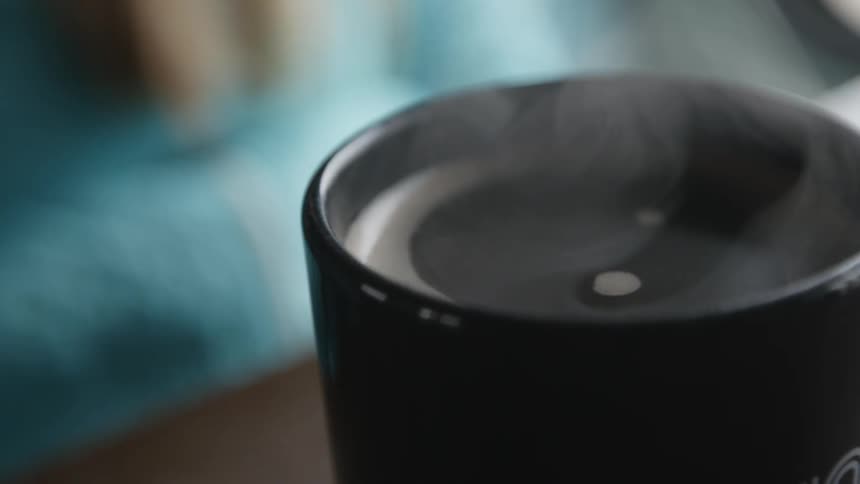 Steam pours from a cup of coffee