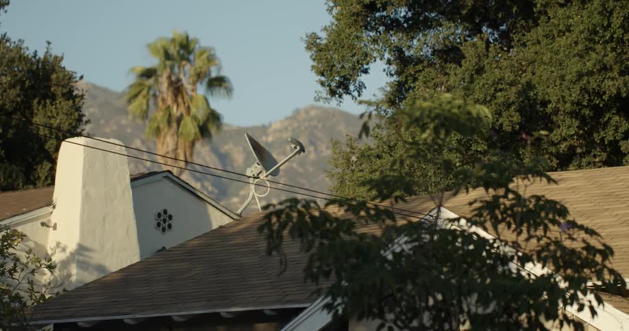 Power lines hang from a house which has a satellite dish