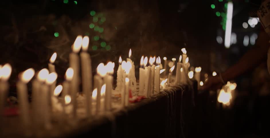 Candles burn and blow in the breeze