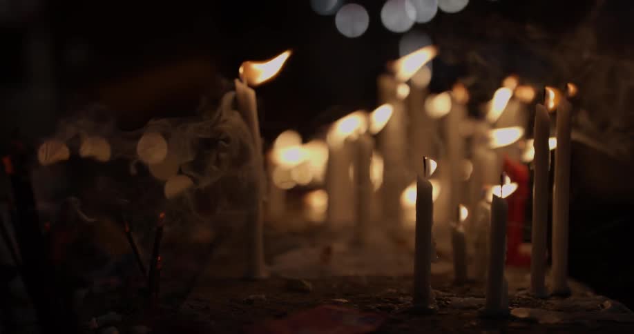 The candles are all lit and melting at night