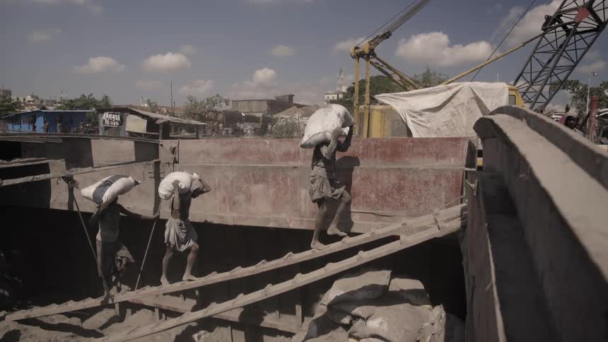 People carry materials onto a barge