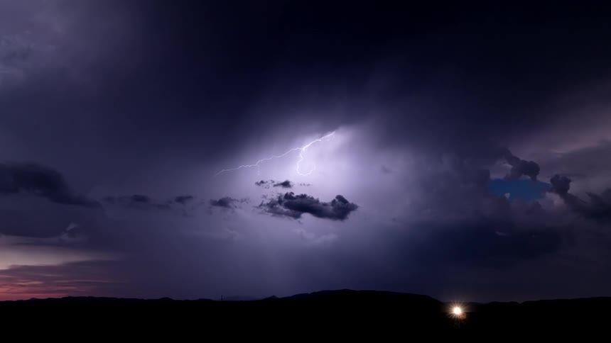 Storm clouds flowing across the sky after sunset as lightning strikes