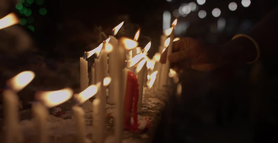 A person moves one of the lit candles