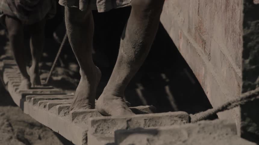 People walk barefoot across a small bridge