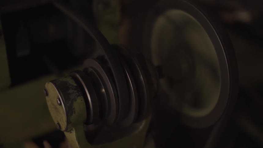 A machine with a spinning belt rotates in a shop