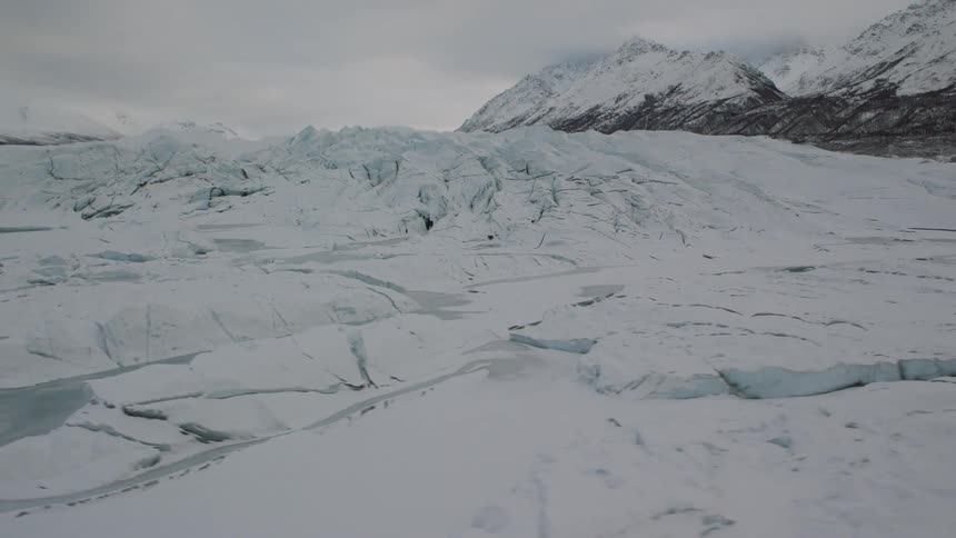 Pullback traverse of an icy glacial snow field in a mountain valley